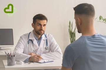 Мужчина сидит на приеме у врача